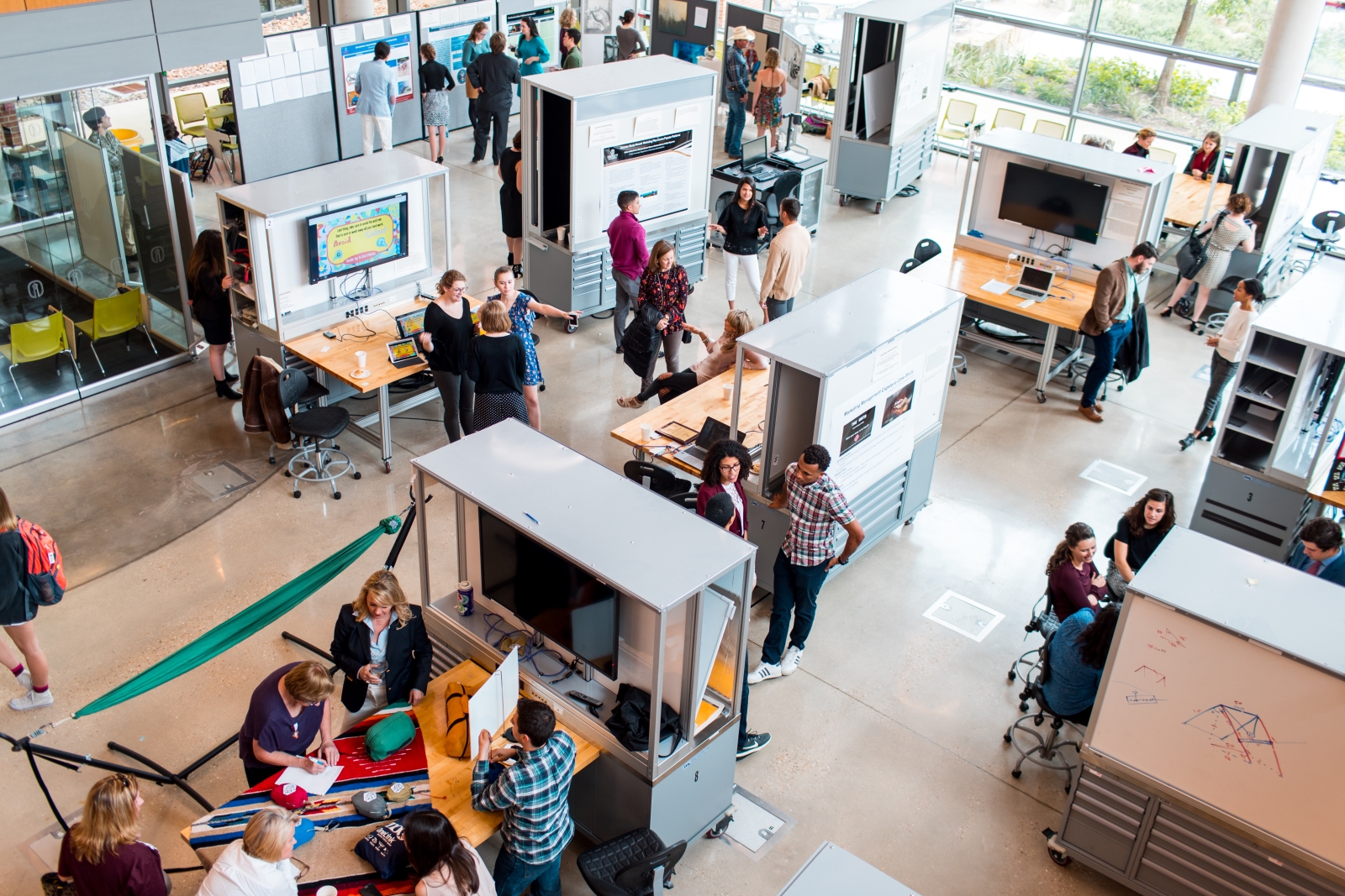an aerial view shows dozens of students and faculty showcasing research posters and projects in the CSI Cube