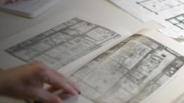 Art History student reviews architectural drawing in a book 