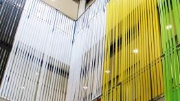 Colored ribbons spanning two stories are part of art exhibition