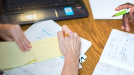 Two students making making notes in multiple notebooks