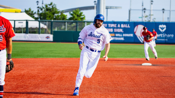 jeremy wolf, wearing a baseball uniform representing israel, runs the bases during a baseball game