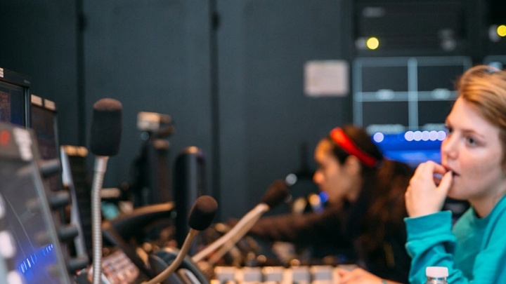 Three female students work the communications console at Trinity's newsroom, TigerTV