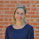 Faculty headshot of Angela Breidenstein in a blue blouse in front of a brick wall