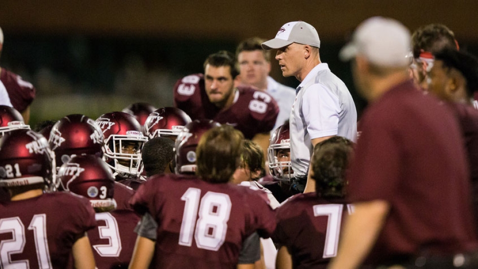 Jerheme Urban speaks to huddled football players