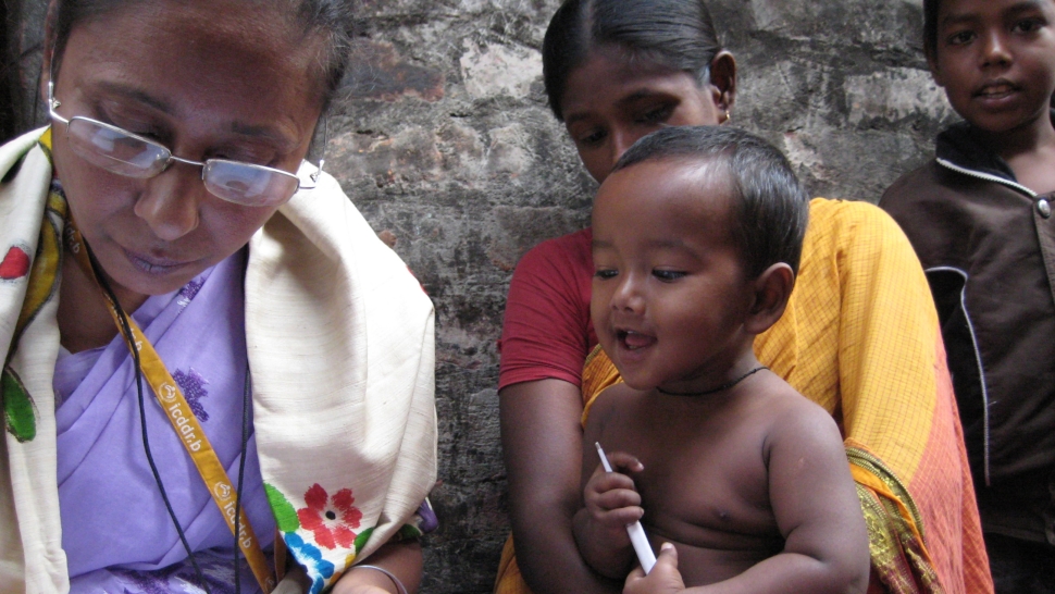 Three children in Bangladesh watch a nurse document administering medication