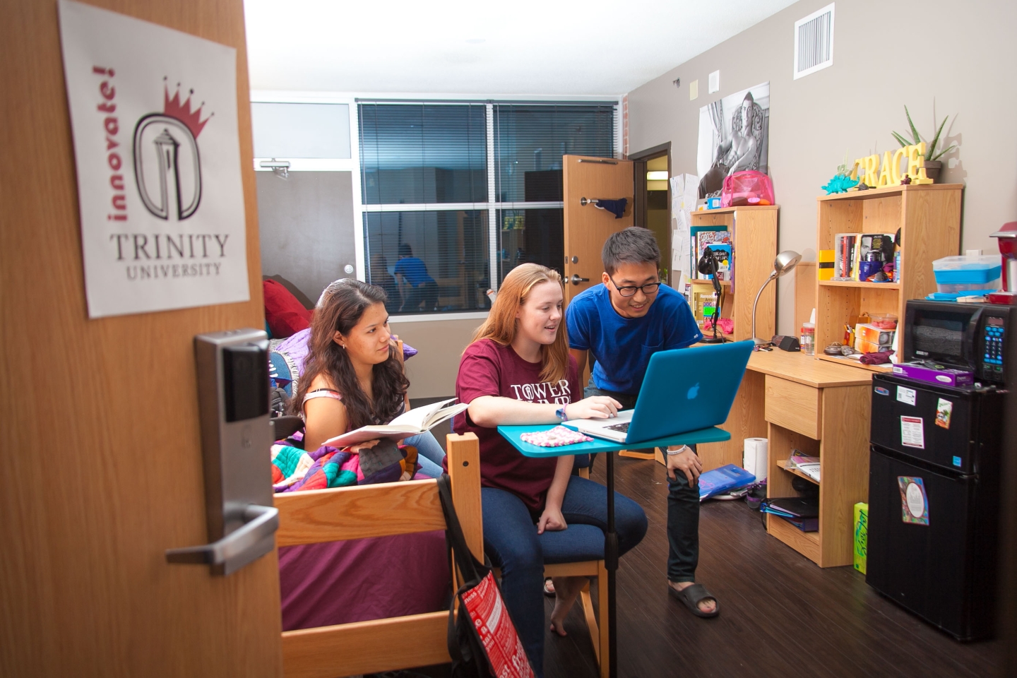 E-Hall students collaborate at desk in dorm room