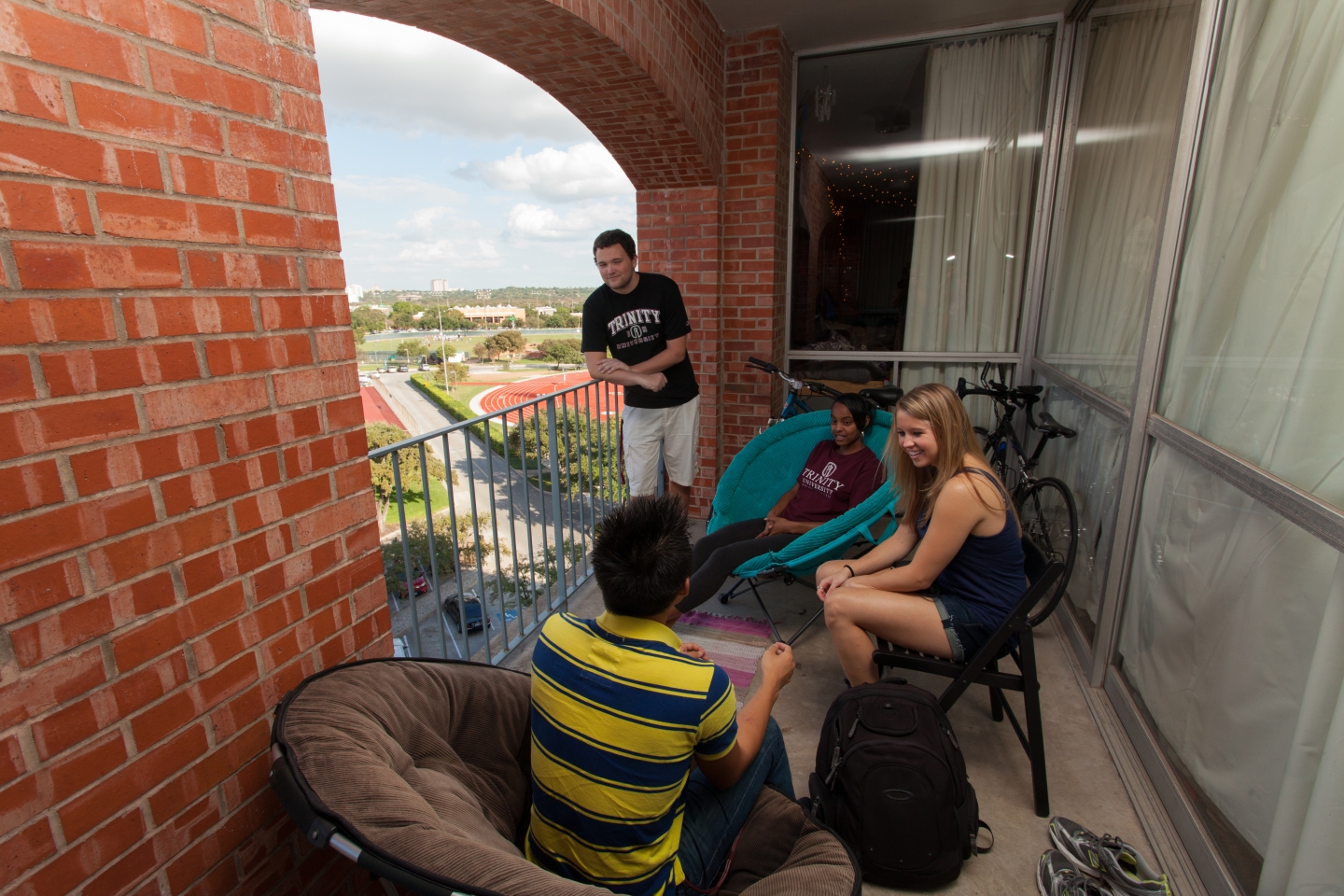 Students hanging out on a balcony in Trinity’s residence halls