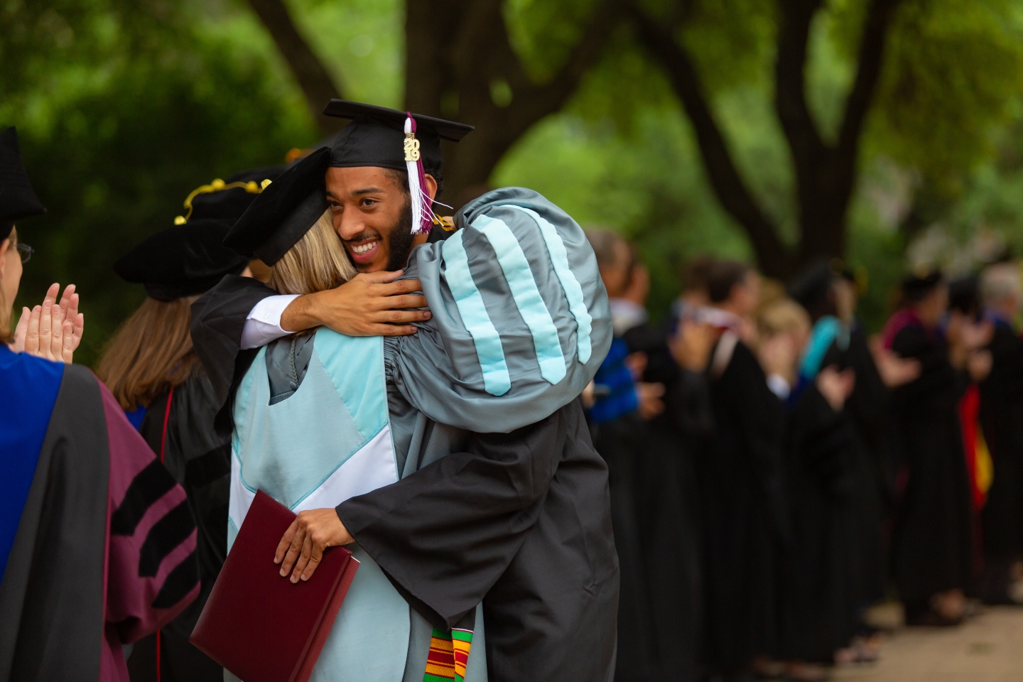 Default: People hugging at commencement 