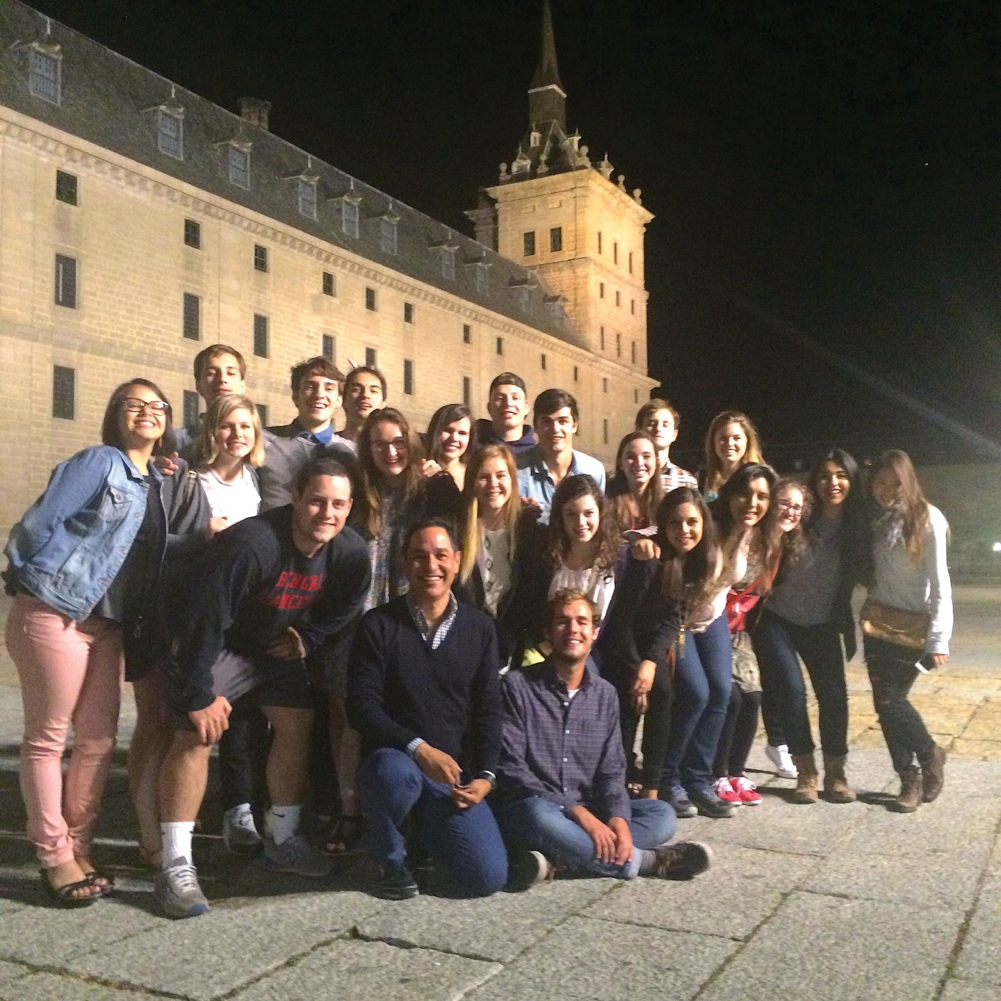 a group of students and faculty pose by El Escorial in Spain
