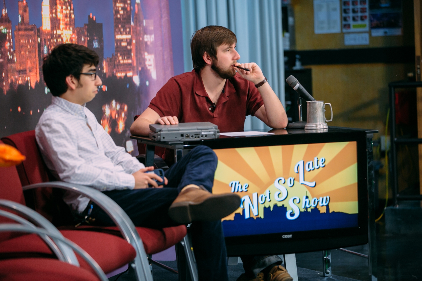 Two students are filming the Not So Late Show on the TigerTV set.