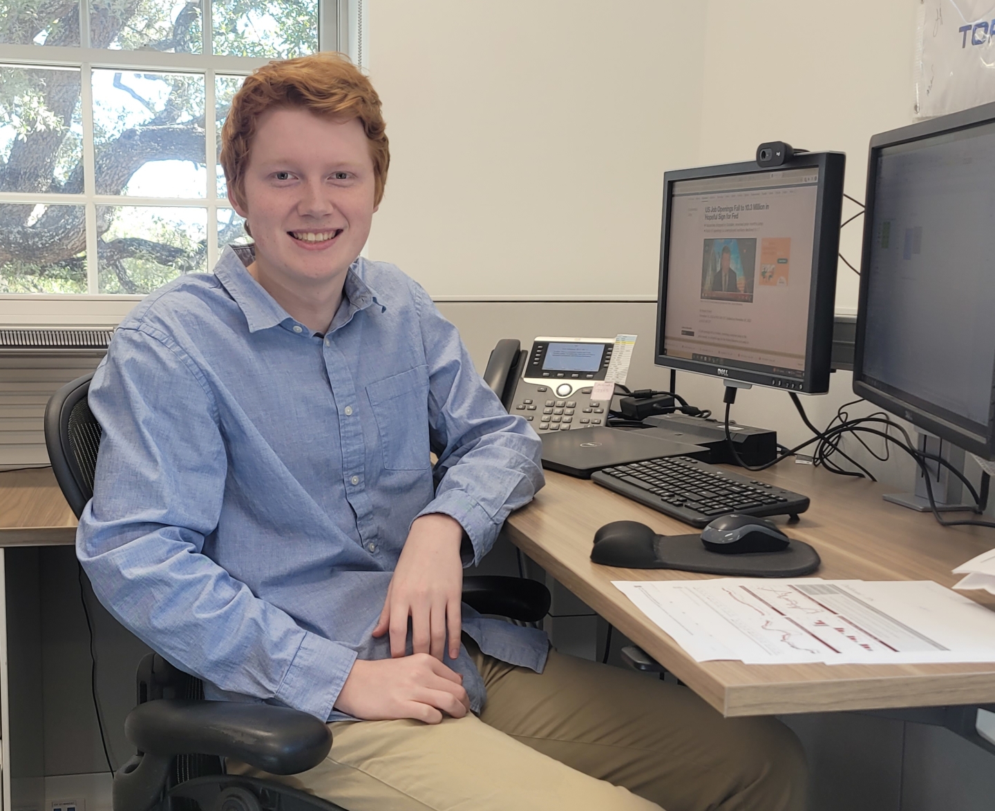 photo of Deral Robison - Trinity Endowment Analyst Intern sitting at a desk with computer screens