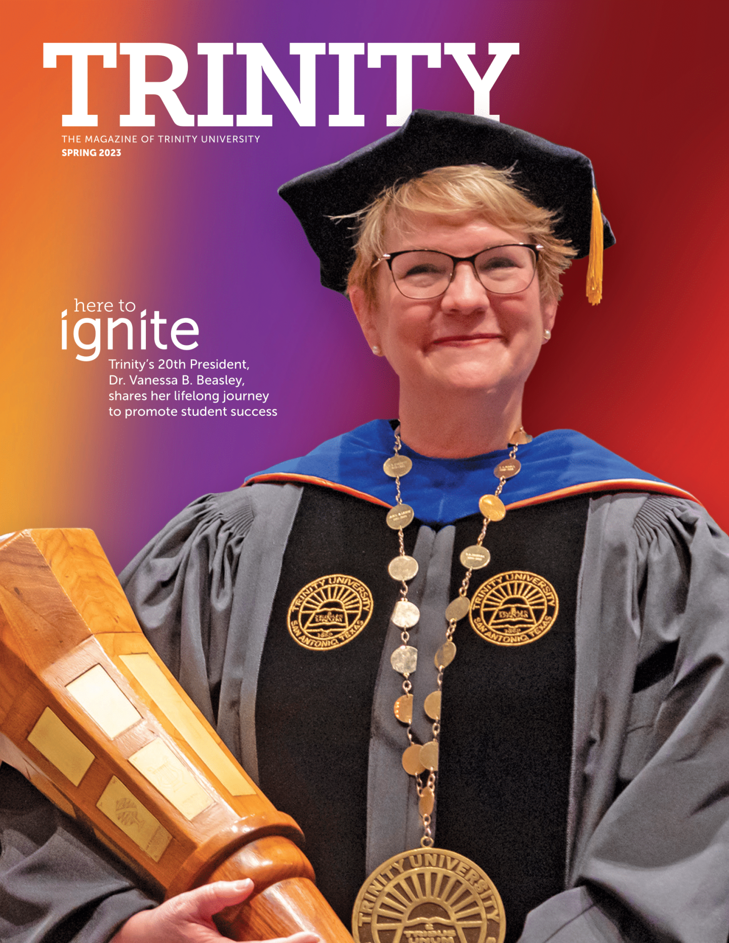 the cover of Trinity magazine Spring 2023; A portrait of Vanessa Beasley holding the presidential mace in full regalia in front of a colorful gradient