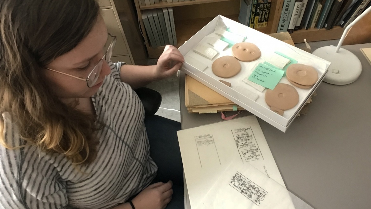 student looking at a book with art images