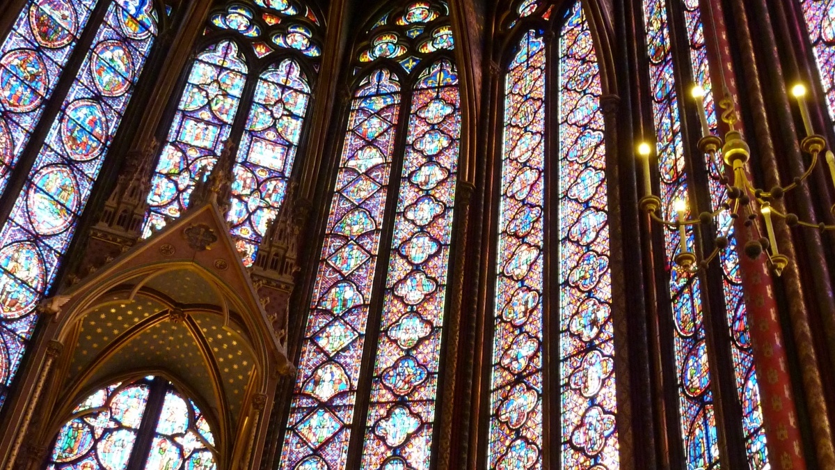 looking up to a large cathedral ceiling supported by swaths of stained glass