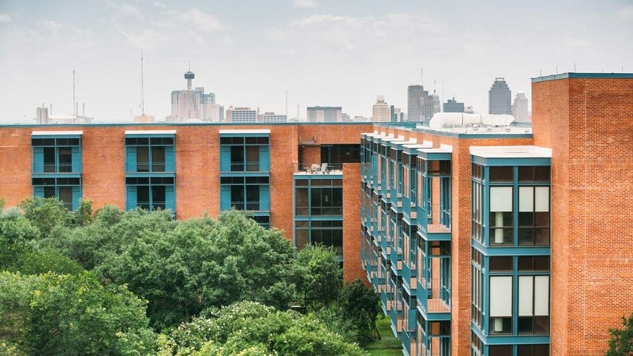 Exterior view of Prassel Hall with San Antonio skyline in the background