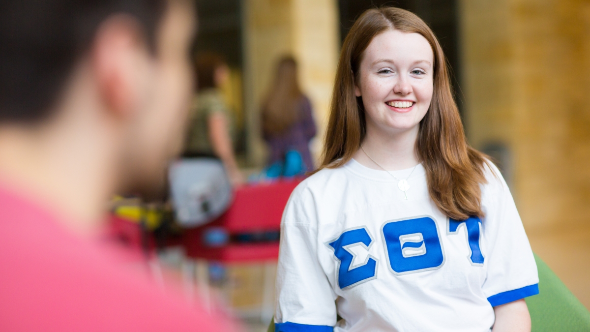 a woman in a Sigma Theta Tau jersey smiles