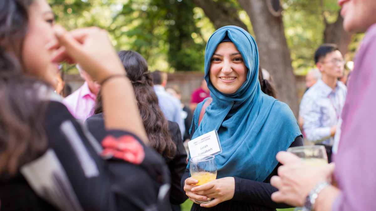 a woman in a hijab participates in a banquet outdoors