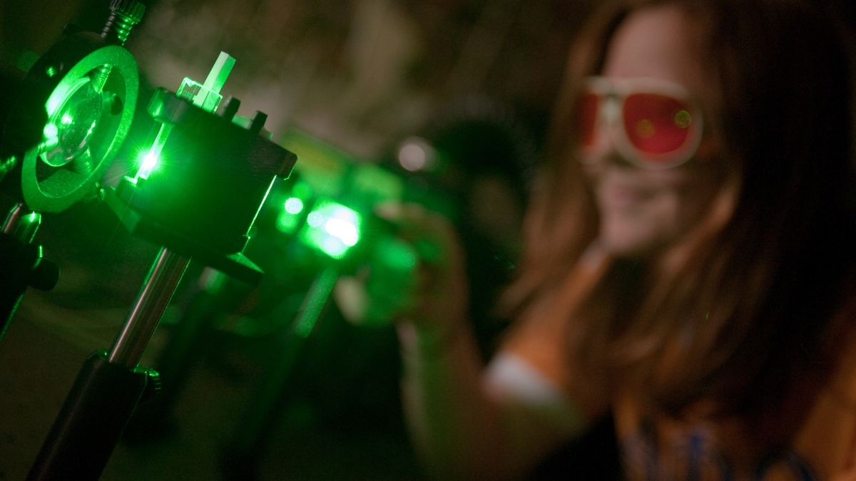 Student with protective glass in photonics lab
