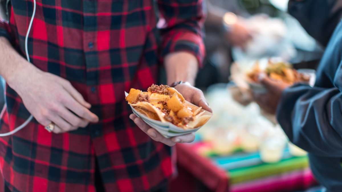 a close up photo of a student holding a boat of nachos