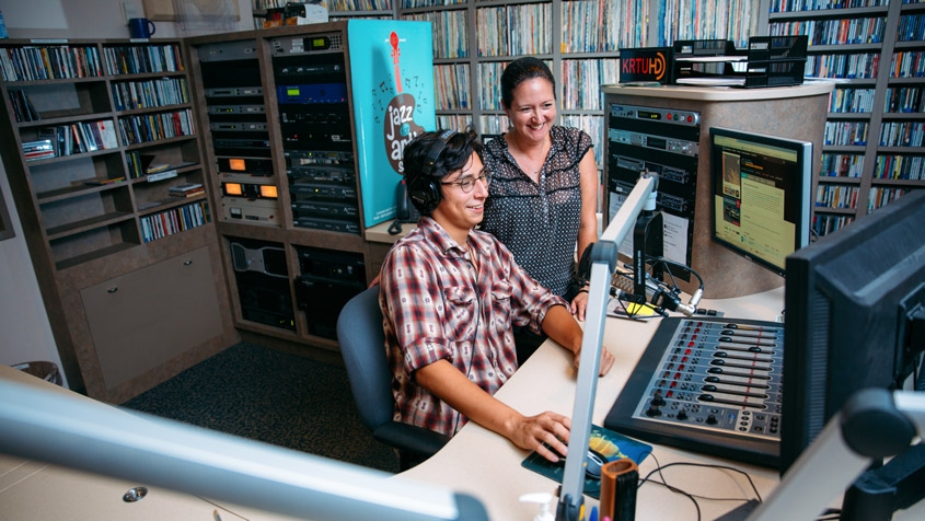 a student and staff member work on-air in the KRTU studio