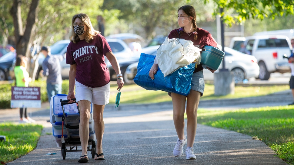 Two students on move in day carrying their belongings