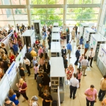 an overhead shot of a large crowd viewing research posters in the CSI cube
